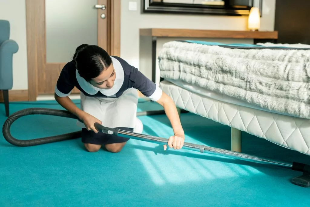 Mitarbeiterin bei der genauen Reinigung eines Hotelzimmers